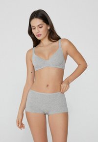 Grijze katoenen bralette met verstelbare bandjes en een V-hals ontwerp. Gecombineerd met bijpassende grijze korte slipjes, beide hebben een gladde textuur.