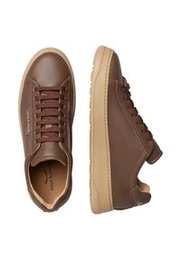 Sneakers in pelle marrone con una texture liscia, punta rotonda e suola in gomma beige a contrasto con dettagli laterali e lacci marroni.
