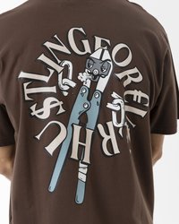 Braunes Baumwoll-T-Shirt mit einem großen Grafikdruck von cartoonhaften Zangen und stilisiertem Text in Weiß und Blau auf der Rückseite.
