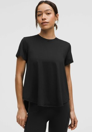Zwarte T-shirt met korte mouwen, gemaakt van zacht materiaal, met een klassiek ronde halslijn, minimaal ontwerp en een comfortabele pasvorm die iets uitloopt bij de zoom.