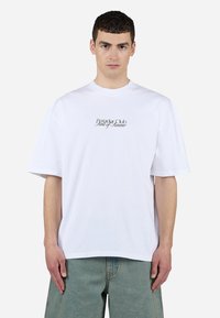 Fehér pamut póló, kerek nyakkal és rövid ujjakkal. "Paradise Club Scent of Summer" felirat fekete betűkkel a elején.