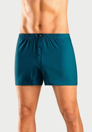 Male torso wearing teal button-front boxer shorts against a plain light background.