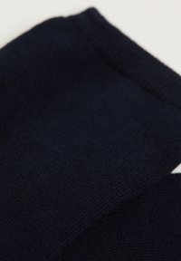 Marinblå bomullssockor med en slät textur, med ribbade muddar och en enkel design, som visar på mjukt, stretchigt material.