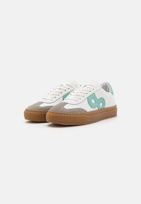 White leather sneakers with gray suede accents, teal design elements, rubber sole, and round toe. Features flat laces and stitched details.