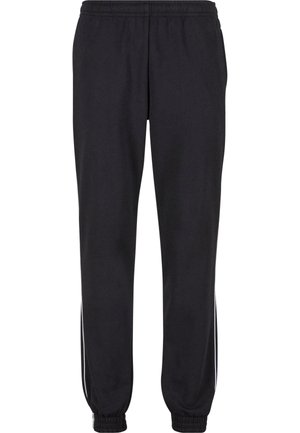 Sorte joggingbukser lavet af en bomuldsblanding, med elastisk talje, tilspidsede manchetter og hvide striber langs siderne af benene.