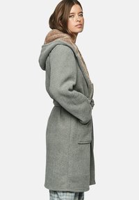 Grijze geweven robe met een zachte beige capuchon, zijzakken en een riem. Het textuurstof en de relaxte pasvorm zorgen voor comfort en warmte.