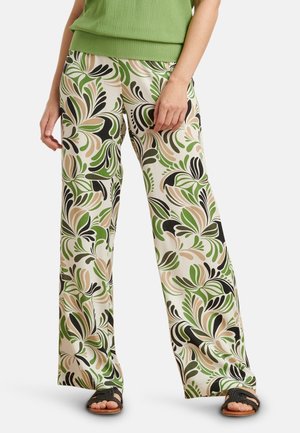 Floral wide-leg trousers in cream with green, black, and beige patterns; lightweight fabric, smooth texture, paired with black sandals.