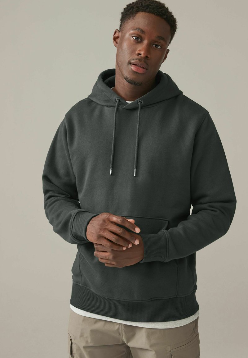 Sudadera gris oscuro con un bolsillo canguro frontal, capucha con cordón, puños y dobladillo acanalados. Fabricada con una suave tela texturizada.
