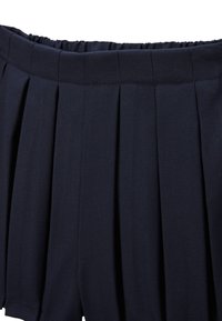 Ceinture en tissu plissé bleu marine avec élasthanne. Matériau texturé présentant des plis verticaux pour un détail de design supplémentaire.