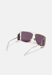 Occhiali da sole con montatura in metallo dorato, lenti rettangolari viola, estremità in acetato trasparente e accenti laterali geometrici. Design leggero.