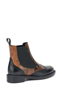 Botas Chelsea marrones y negras con un diseño texturizado de reptil, paneles laterales elásticos y detalles de brogue. Suela de goma y tirador.