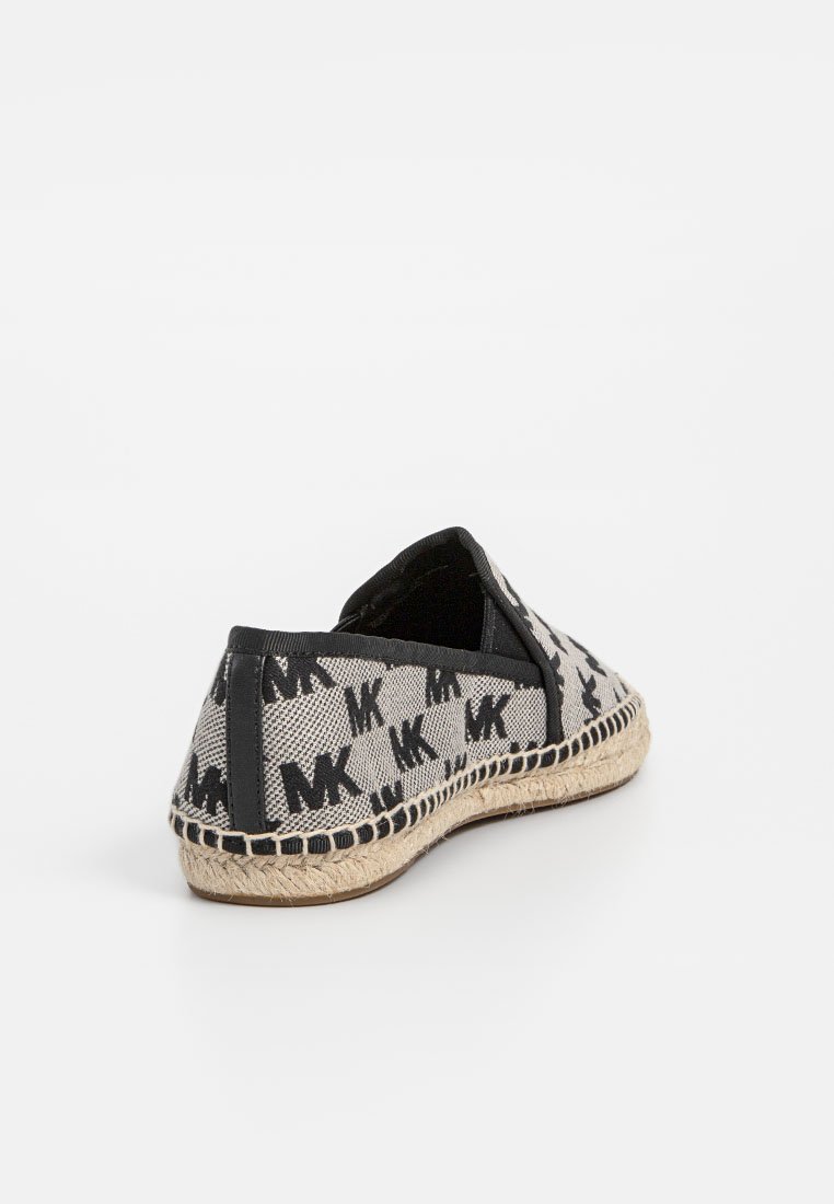 Scarpa espadrillas nera e beige con suola intrecciata, caratterizzata da un motivo ripetuto con logo "MK" e bordatura nera su sfondo bianco.