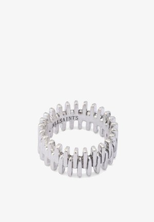 Srebrny metalowy pierścionek z wzorem zygzakowym, teksturowaną powierzchnią i gładkim wnętrzem. Na wewnętrznej stronie znajduje się wygrawerowana nazwa marki.