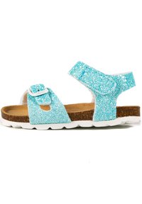 Sandale turquoise pailletée avec deux straps réglables, semelle en liège et semelle en caoutchouc blanc. Présente un dessus texturé et scintillant.