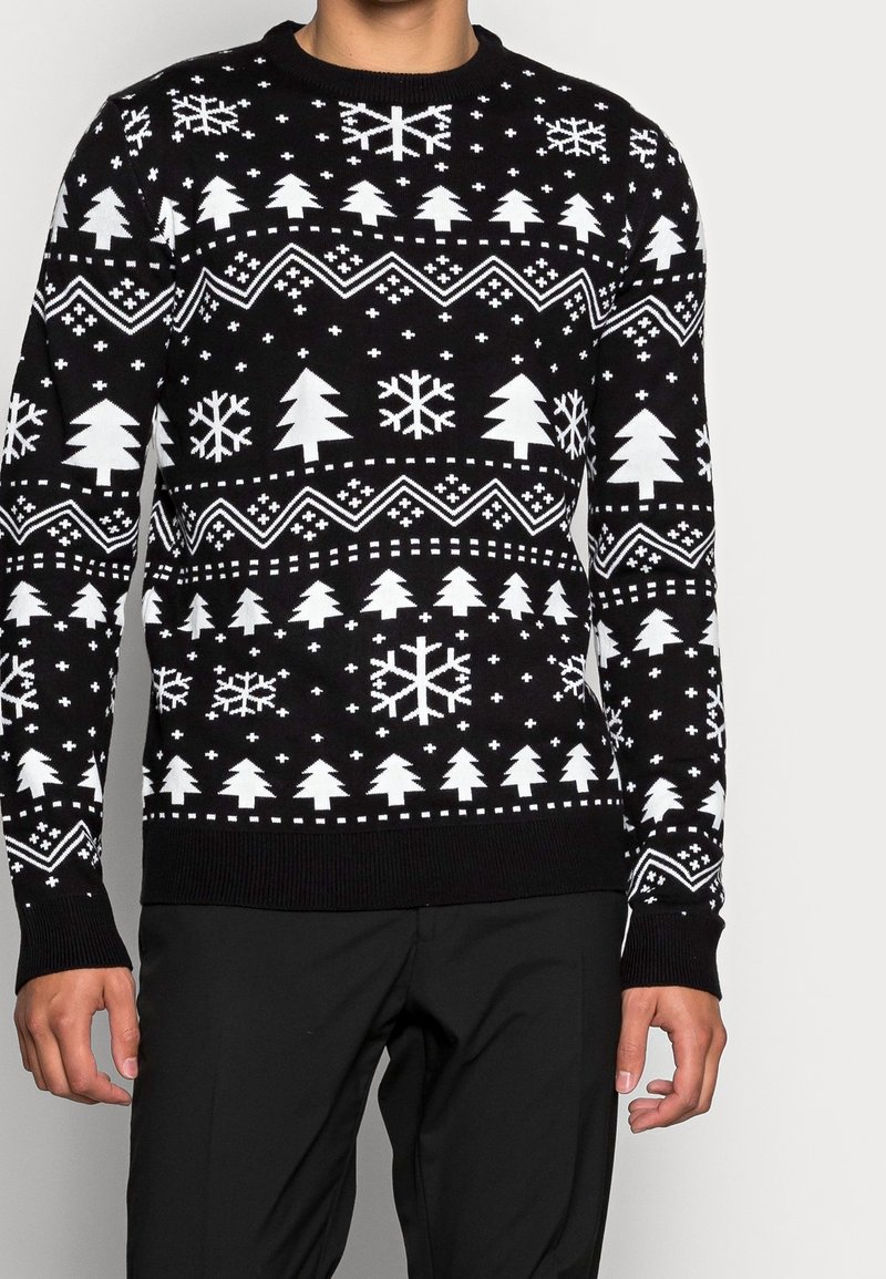 Svart stickad tröja med vita mönster av träd, snöflingor och geometriska former. Rund halsringning och ribbade ärmslut och nederkant.