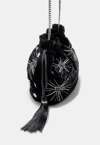 Borsa a sacchetto in velluto nero con ricamo di stella e raggi argentati, con nappina e tracolla a catena. Forma compatta e arrotondata.