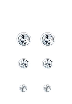 Tres pares de pendientes de botón redondos de cristal transparente en tamaños pequeño, mediano y grande, dispuestos verticalmente sobre un fondo blanco.