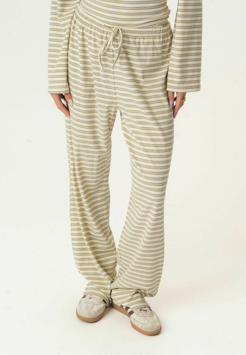 Light beige pants with horizontal olive green stripes, made from a soft material. Features an elastic waistband with a drawstring.