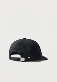 Gorra de béisbol de tela negra vista desde atrás, con una correa ajustable y una hebilla metálica plateada sobre un fondo sencillo y claro.