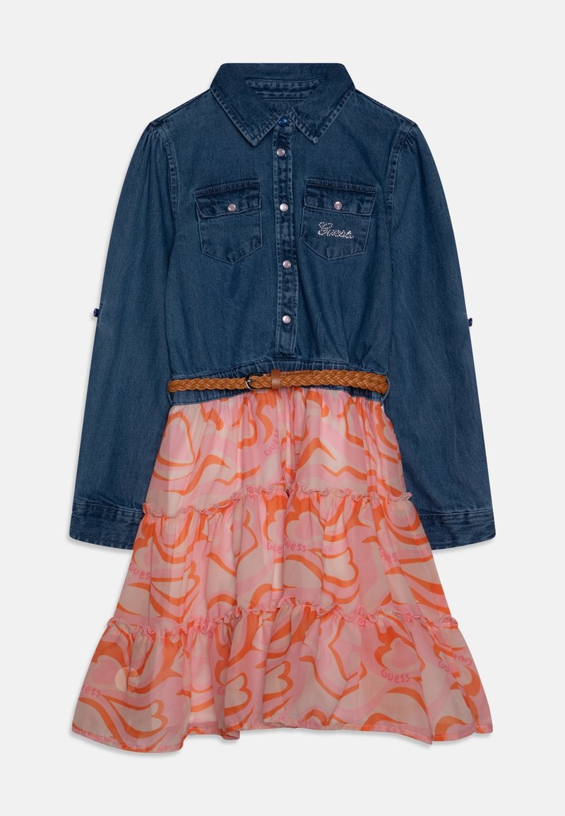 Robe chemise en denim à manches longues avec deux poches poitrine, ceinture tressée marron, et jupe à volants aux motifs rose-orange avec logos "Guess".