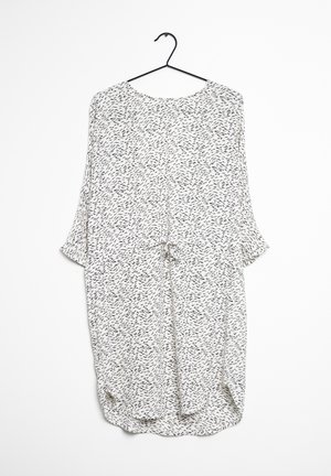 Leichtes, locker sitzendes Kleid in Weiß mit einem schwarzen abstrakten Muster. Es hat einen runden Halsausschnitt, kurze Ärmel und einen Taillengürtel.