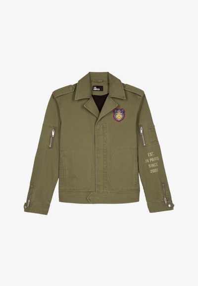 Olijfgroene militaire stijl jas, katoenen stof, voorzakken, zijritszakken, embleemdetails op de linkerborst, tekst op de rechtermouw.
