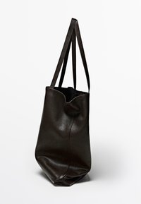 Zwarte leren tote bag met een zachte textuur, gebogen bovenrand en dubbele schouderriemen. Heeft een slouchy silhouette en minimale naden.