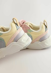 Multifarvede sneakers med en blanding af gule, pink, grønne og grå materialer; teksturerede detaljer; og løftenaps til nem påtagning.