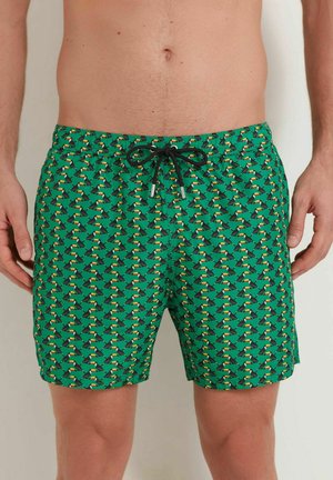 Pantaloni de baie verzi cu un model repetitiv de păsări tropicale, talie elastică cu șnur și un material ușor, care se usucă rapid.