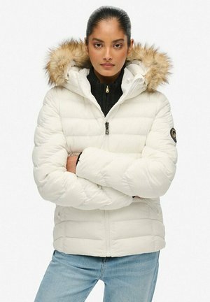 Witte donsjas met een capuchon met bontafwerking, doorgestikt ontwerp, ritssluiting aan de voorkant en een logo-accent op de mouw. Draagt over een zwarte coltrui.