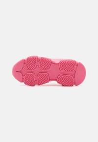 Suola di scarpa sportiva rosa con una presa in gomma testurizzata che presenta motivi a zigzag e un design della punta arrotondata. Superficie liscia e bordi arrotondati.