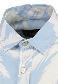 Chemise à manches courtes en tissu bleu clair ornée de motifs abstraits blancs, avec un col à boutons et une étiquette portant la mention "Key Largo."