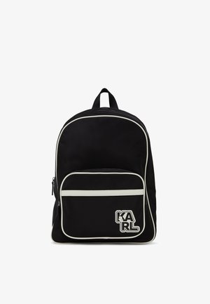 Must mustra seljakott valgete ääristustega, esiosas lukuga tasku ja logoga, millel on kiri "KARL". Sile tekstuur, ümmargune kuju.
