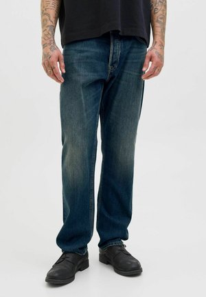 Blå denimjeans med avslappnad passform, något urtvättad fram och en klassisk femficksdesign; parat med svarta skor.