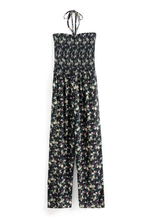 Combinaison noire à fleurs sans bretelles avec corsage froncé et liens noués autour du cou, pantalons larges, ornée de motifs floraux verts, violets et beiges.