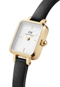 Square gold-tone watch with a white dial, gold hands, and a black leather strap. Features a textured strap and a crown for adjustment.