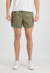 Olivengrüne Cargo-Shorts aus leichtem Material, mit zwei Seitentaschen und einer lockeren Passform, kombiniert mit weißen Sneakers und einem schlichten weißen T-Shirt.