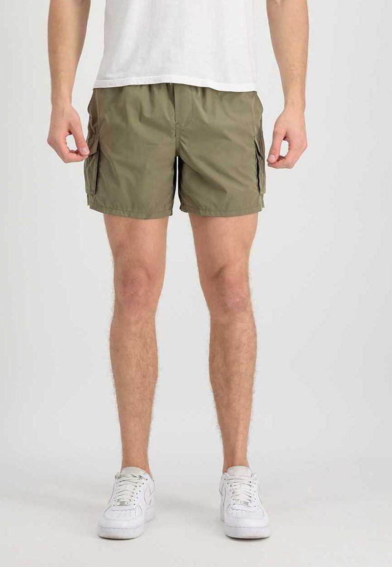 Olivengrüne Cargo-Shorts aus leichtem Material, mit zwei Seitentaschen und einer lockeren Passform, kombiniert mit weißen Sneakers und einem schlichten weißen T-Shirt.