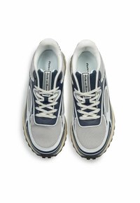 Marineblau und graue Sportschuhe mit Obermaterial aus Mesh, weißen Akzenten und abgerundetem Zehenbereich. Eigenschaften umfassen eine hellfarbige Sohle mit strukturiertem Profil und Schnürsenkeln.