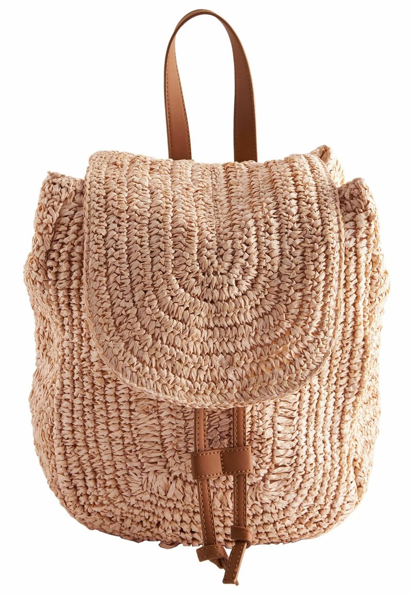 Petit sac à dos beige tissé avec rabat arrondi et fermeture par sangle en cuir marron et poignée.