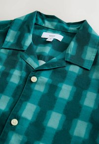 Cămașă cu mânecă scurtă în nuanțe de teal și verde, având un guler clasic, nasturi mici și o textură de material neted și moale.