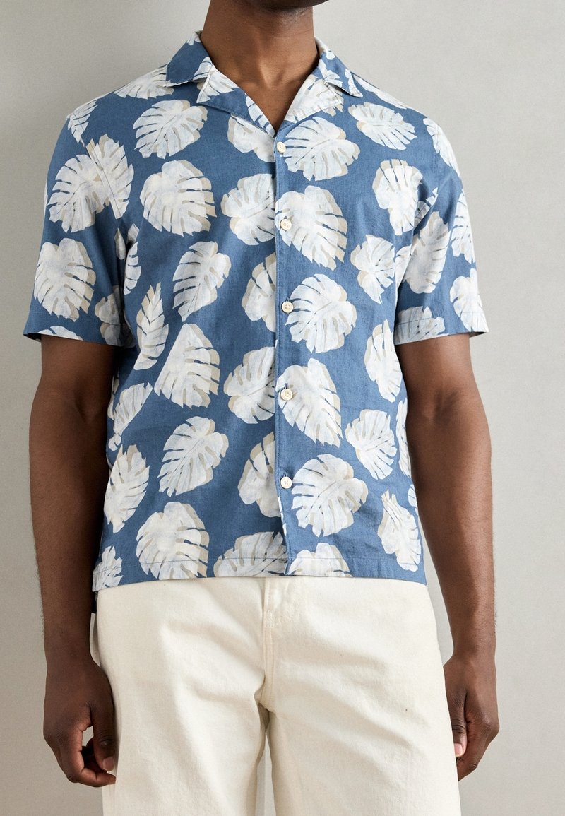 Kurzärmeliges Hemd aus blauem Stoff mit weißen Blattmustern, mit Kragen und Knopfleiste, hergestellt aus leichtem Material.
