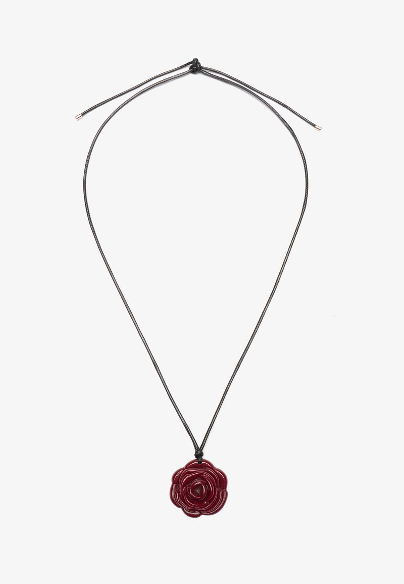 Pendentif en résine rouge en forme de rose sur un cordon noir. La rose présente des pétales superposés avec une finition brillante, suspendue à une fermeture par nœud réglable.