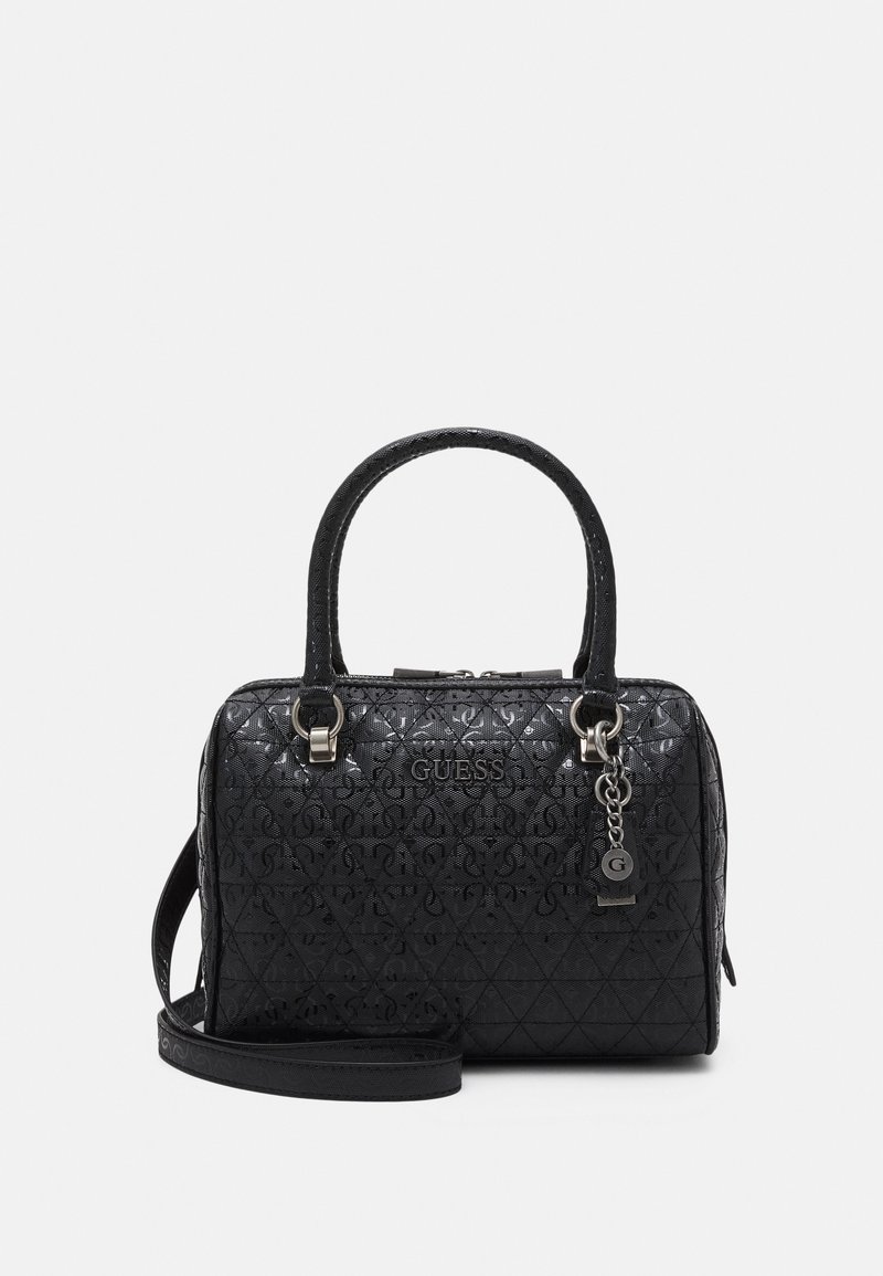 Sac à main matelassé noir Guess avec double poignées, bandoulière détachable et porte-clés orné argenté à l'avant sur fond blanc.