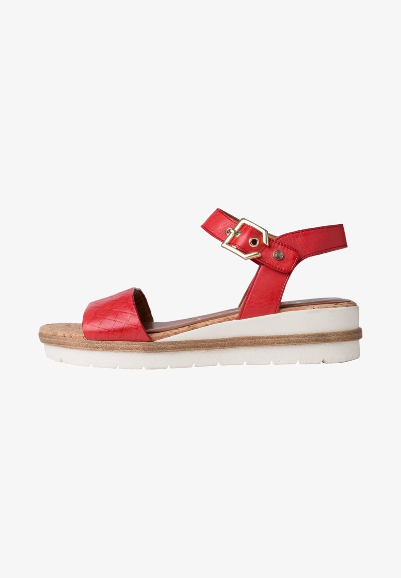 Sandale rouge à bout ouvert avec bride à la cheville et boucle dorée, semelle intérieure en liège rembourrée, et semelle plateforme blanche avec couche intermédiaire beige.