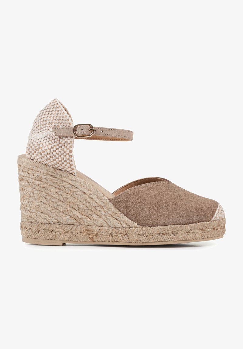 Espadrille à talon compensé en daim marron avec des accents beiges tissés, bout ouvert, bride de cheville et plateforme en jute. Design texturé et contemporain.