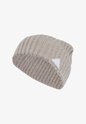 Gorro hecho de tejido de punto en un tono beige claro. Presenta una textura acanalada y una pequeña etiqueta de logo blanca en el lateral. Forma clásica de gorro redondeado.