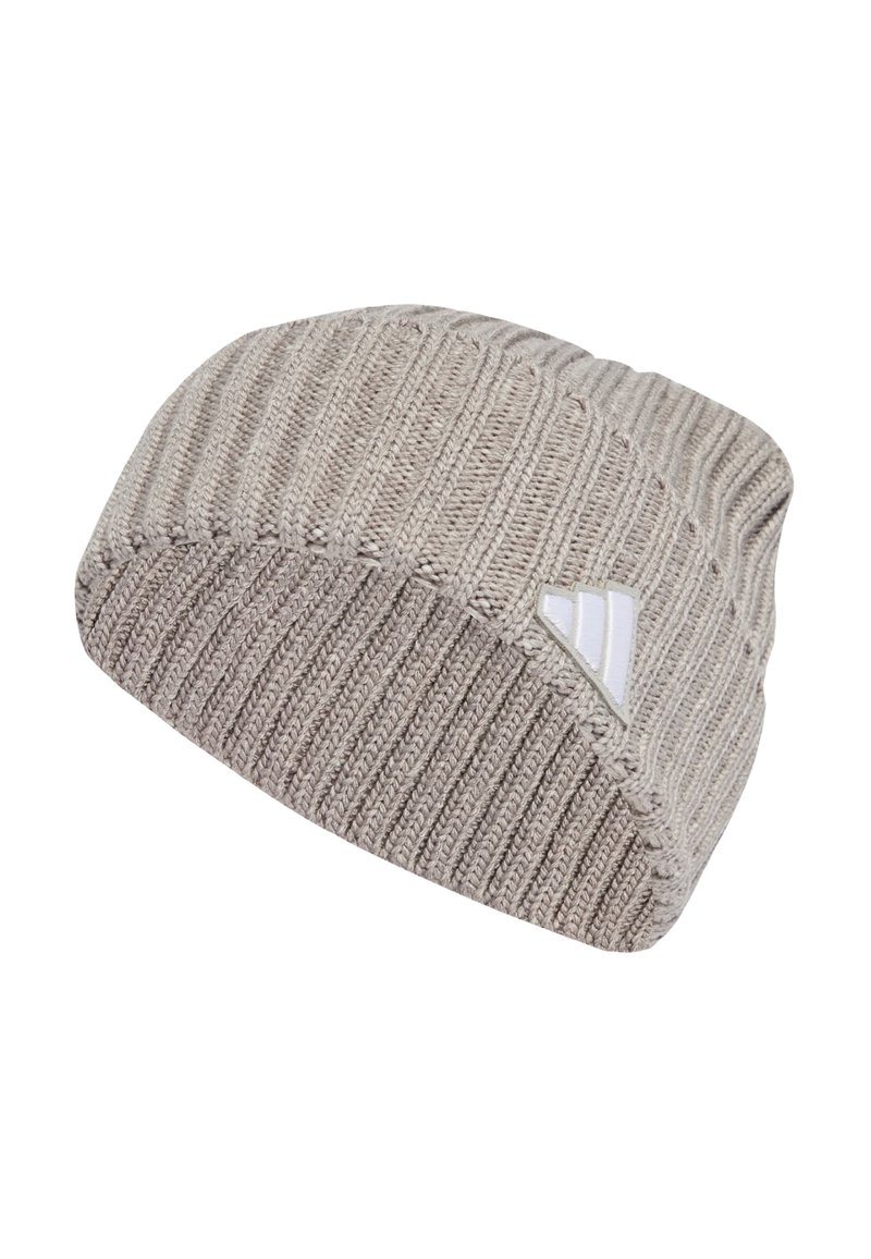 Beanie made of knitted fabric in light beige. Features ribbed texture and a small white logo tag on the side. Classic, rounded cap shape.