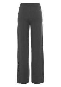 Graue, weit geschnittene Sweatpants mit glatter Textur, elastischem Taillengummi und schwarzem "SAND"-Logo, das an der Seite aufgedruckt ist.