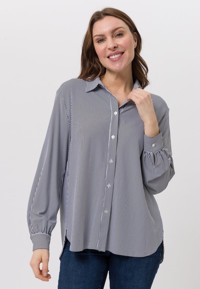 Gestreifte Bluse aus marineblauem und weißem Baumwollstoff, mit durchgehender Knopfleiste, langen Ärmeln mit Manschetten und einem lockeren Schnitt mit Seitenschlitzen.